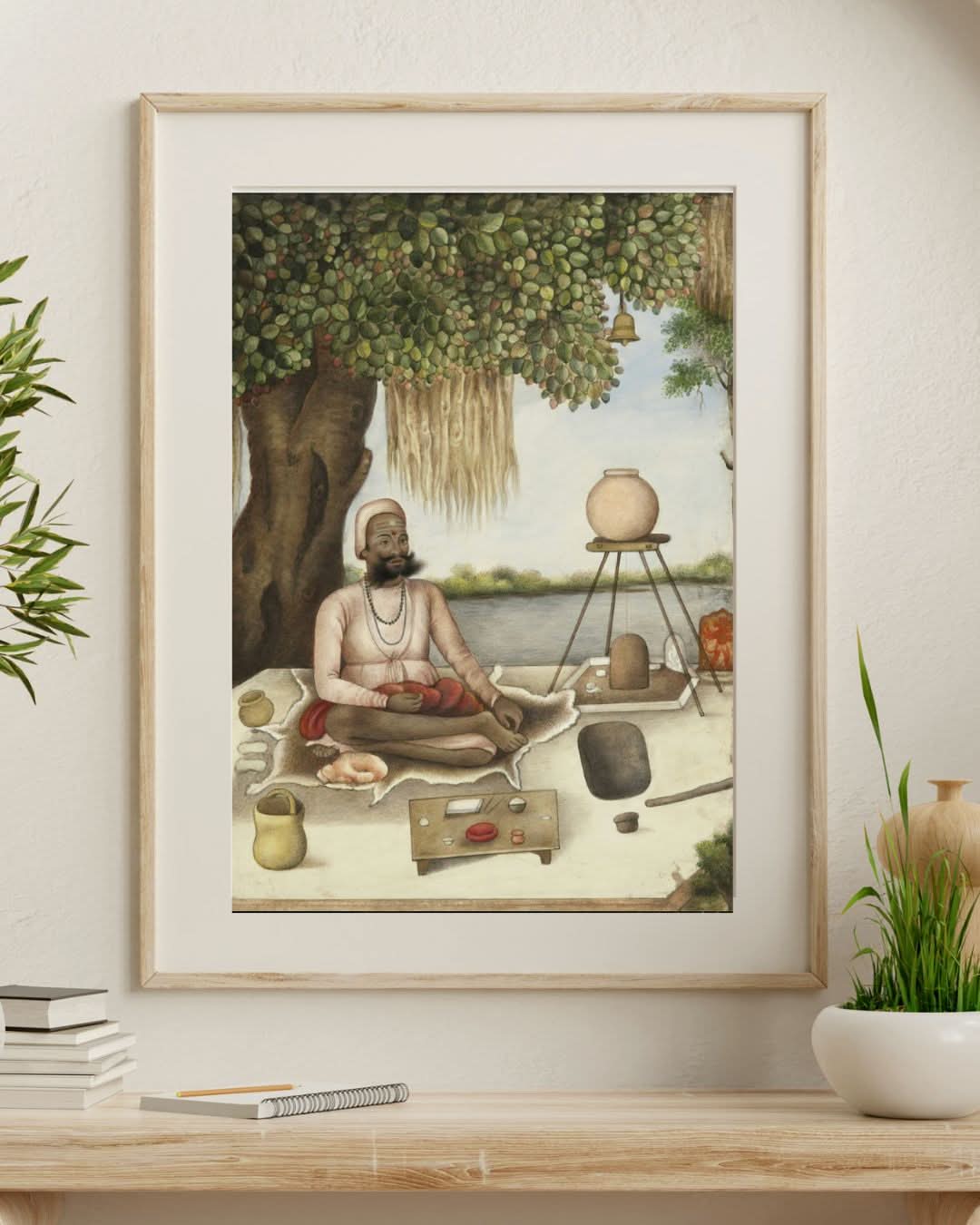 Framed artwork of a meditating figure in a natural setting on a wall above a desk.