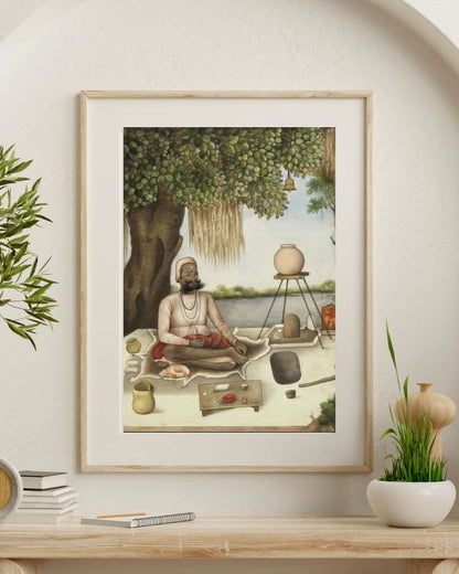Framed artwork of a man in a meditative pose on a table with decorative items.