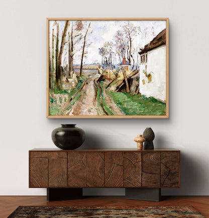 Framed painting of a rural scene above a wooden sideboard with decorative items.