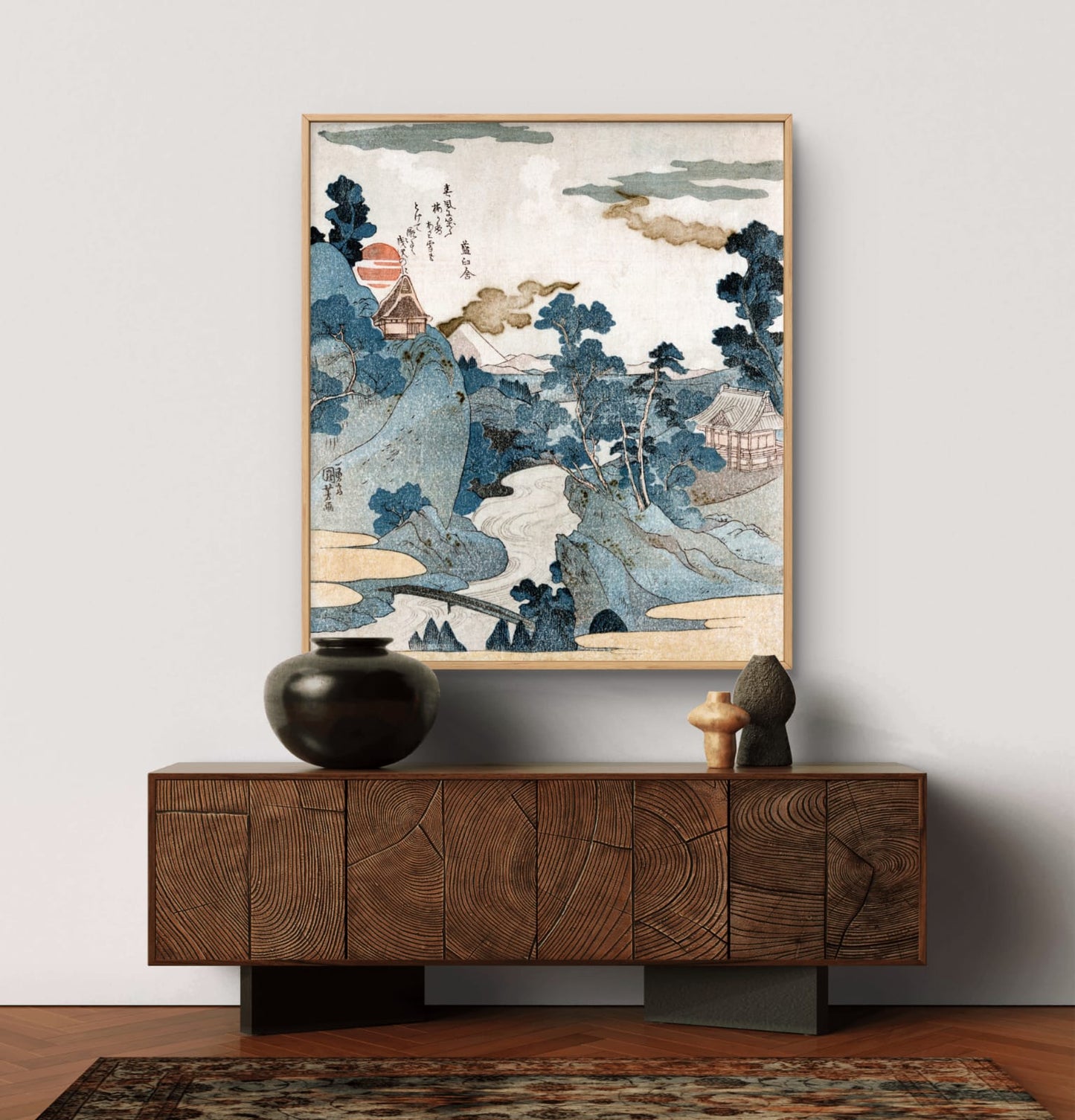 Framed artwork of a landscape above a wooden cabinet with decorative items.