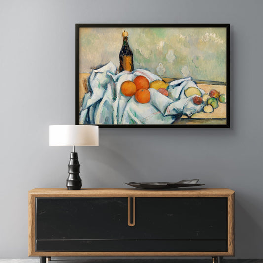 Framed painting of a still life scene above a wooden cabinet with a lamp and decorative items.
