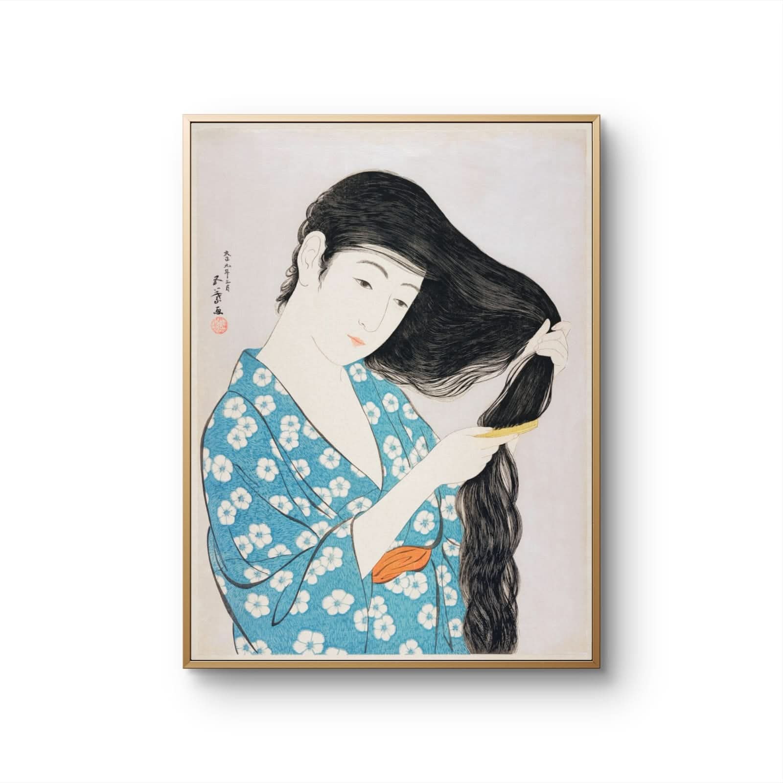 Framed artwork of a woman in a blue kimono with white flowers, combing her hair.
