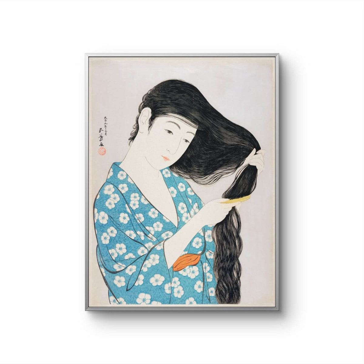 Framed artwork of a woman in a blue kimono with white floral patterns, combing her hair.