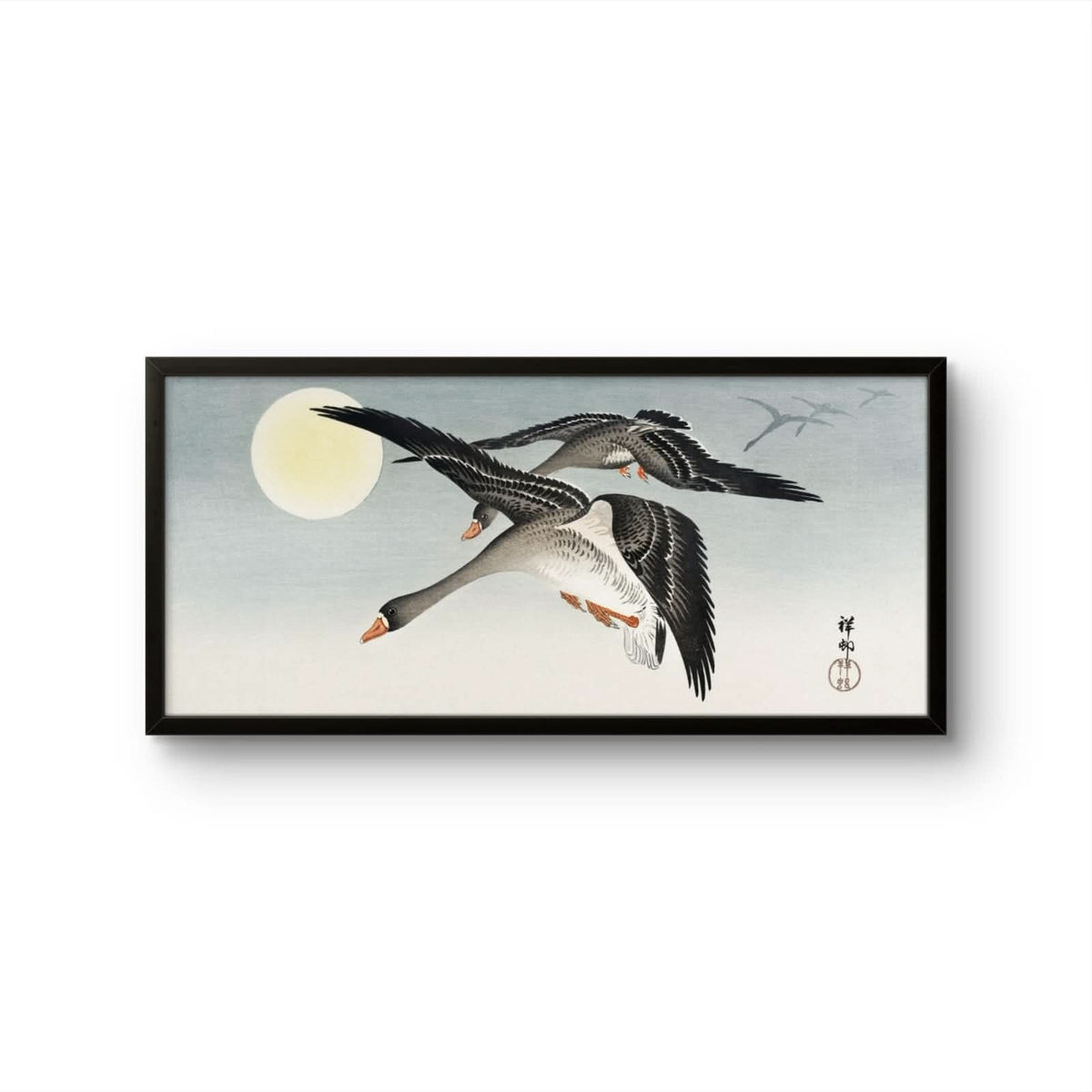 Framed artwork of two geese flying with a moon in the background