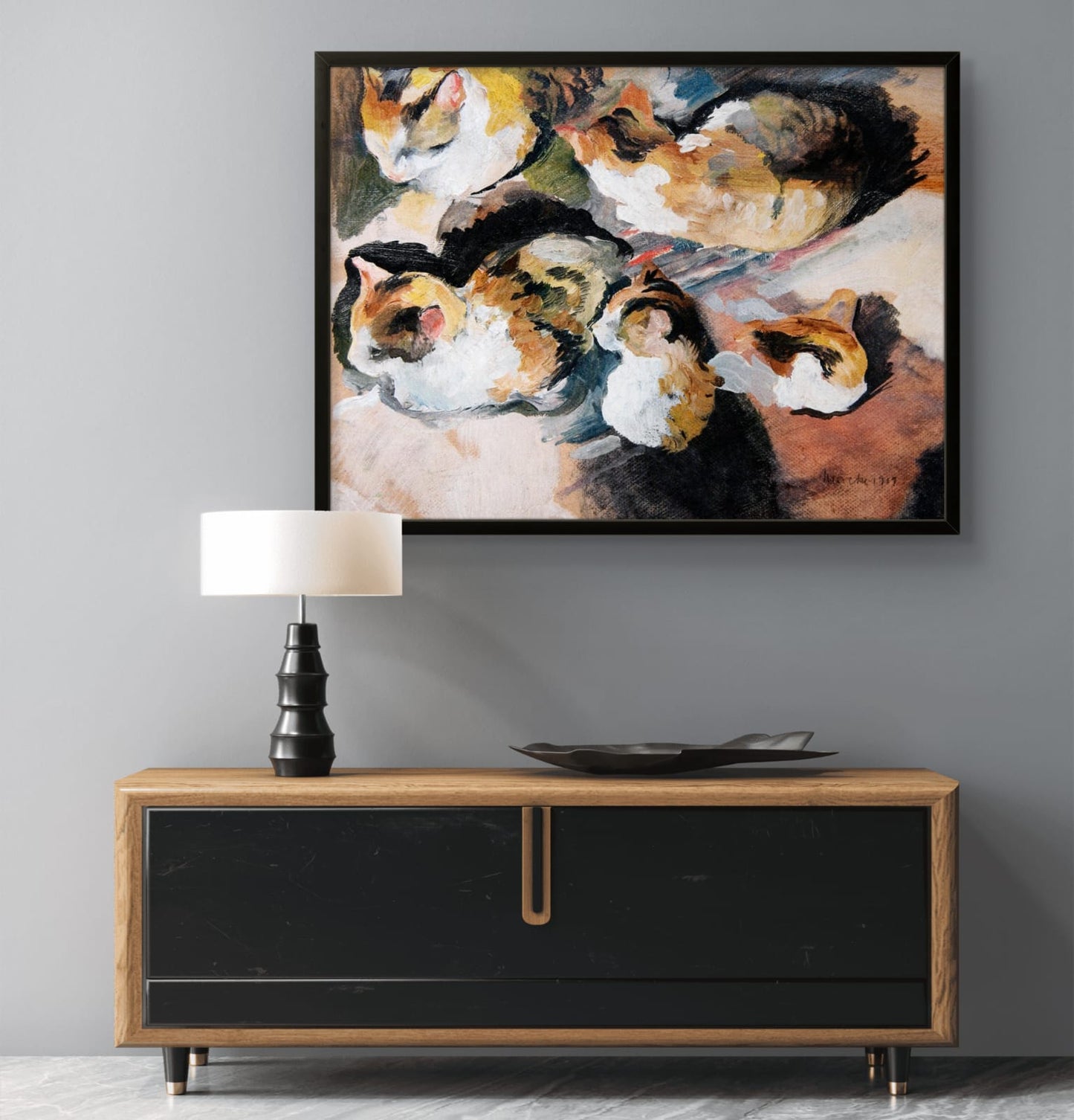Framed painting of cats above a wooden console table with a lamp and decorative plate.