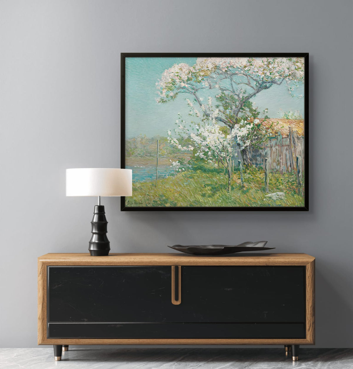 Framed artwork of a cherry blossom tree on a gray wall above a wooden console table.