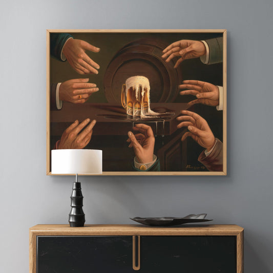 Framed artwork of hands reaching towards a beer mug on a gray wall above a wooden cabinet.