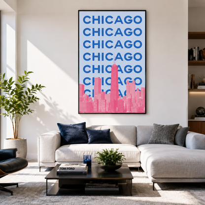 A framed wall art print featuring the word 'CHICAGO' in blue stacked text above a pink skyline, displayed above a light gray sectional sofa in a modern living room.