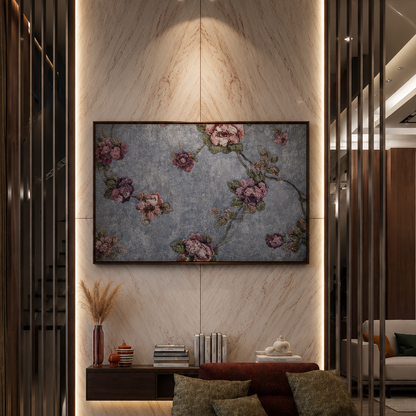 A framed floral wall art piece with pink blossoms on a textured gray-blue background, displayed in a modern living room setting above a dark red sectional sofa.