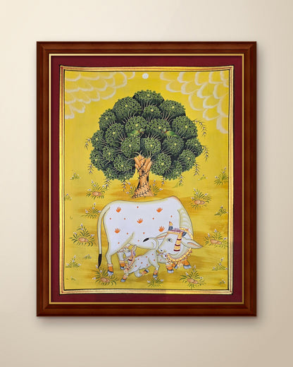 Kamdhenu Under the Kadamb Tree - Yellow Pichwai shown in a walnut wood frame (frame sold separately)