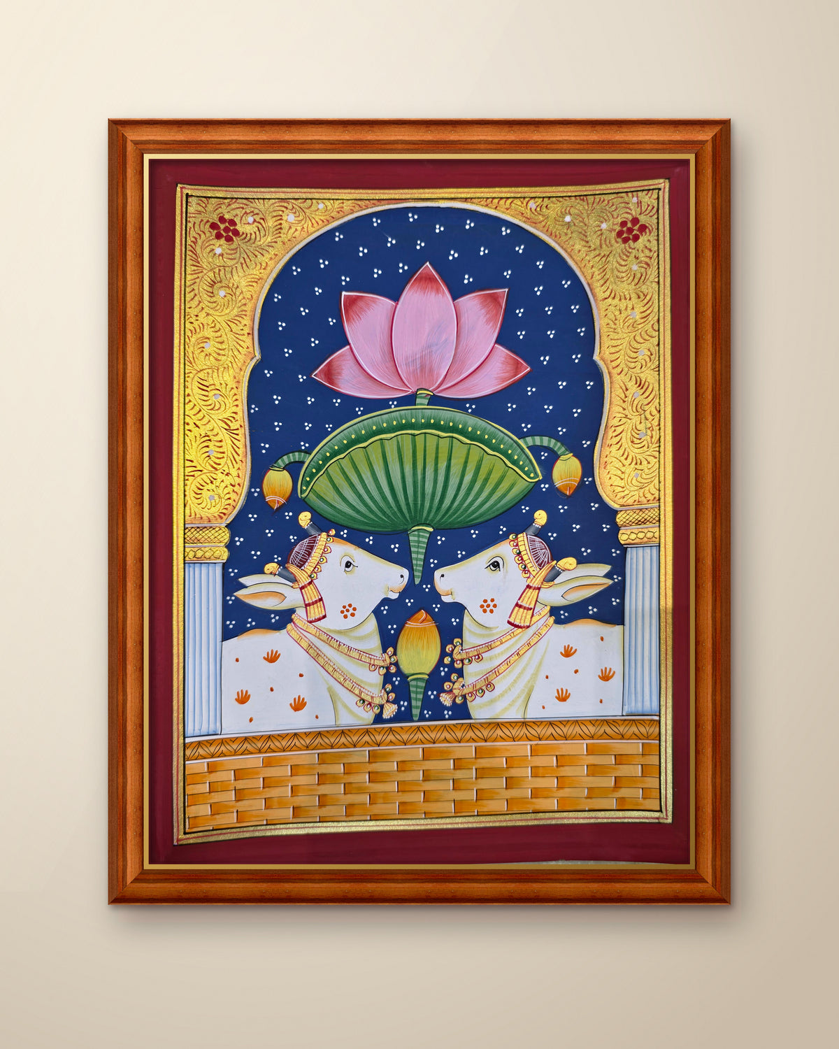 Twin Gaumata Under the Lotus Arch - Navy Pichwai shown in a teak wood frame (frame sold separately)